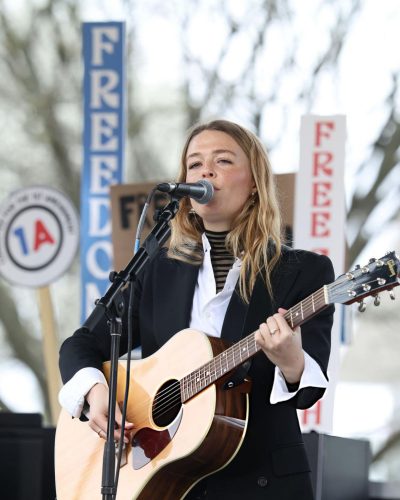 Maggie Rogers in a stylish striped turtleneck and skinny jeans.