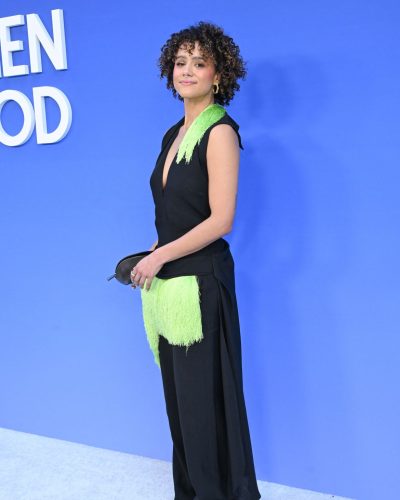 Nathalie Emmanuel in black V-neck top with vivid green fringe accents