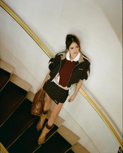 Nina Dobrev black mini skirt with warm-toned color-block jacket