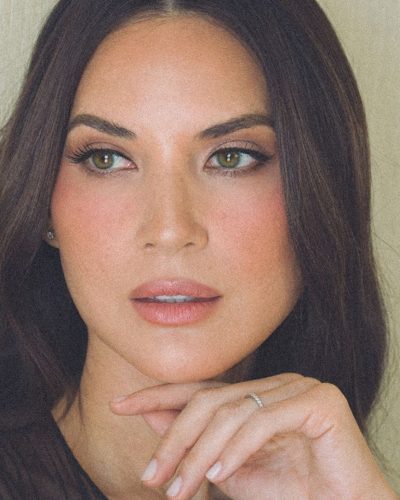 Olivia Munn wearing a navy blue dress with elegant draping.