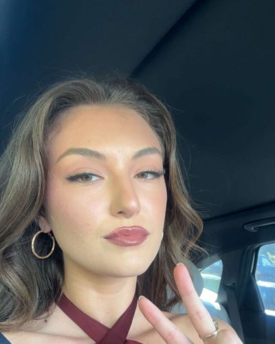 Rachel Pizzolato fashionable burgundy dress with distinct silhouette