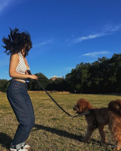 Rachel Zegler in loose waves hairstyle with bright yellow scrunchie.