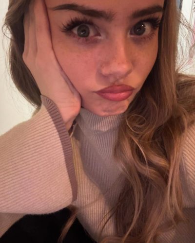 Sara Crumbleleg dressed in a cozy beige sweater and tailored shorts