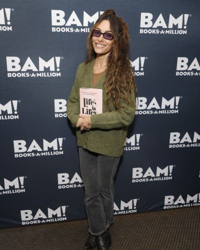 Sarah Shahi in a relaxed green cardigan and brown top combination.