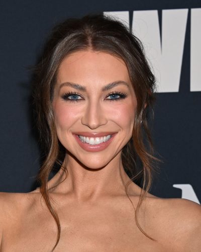 Stassi Schroeder in strapless black gown with soft waves hairstyle.