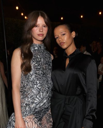 Taylor Russell in tailored black satin button-up shirt and high-waisted trousers.