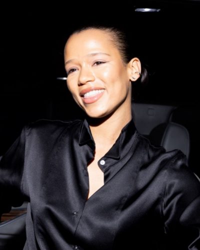 Taylor Russell wearing minimalistic accessories with black satin shirt.