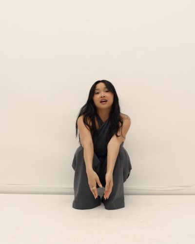 Lana Condor in fitted grey jumpsuit with contemporary twist.