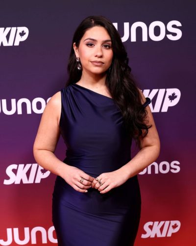 Alessia Cara long navy gown paired with sparkling earrings