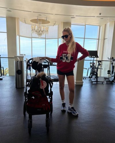Alexa Serowik in a red sweater and black shorts enjoying beach vibes.