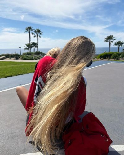 Alexa Serowik in a red sweater and comfortable black shorts outdoors.