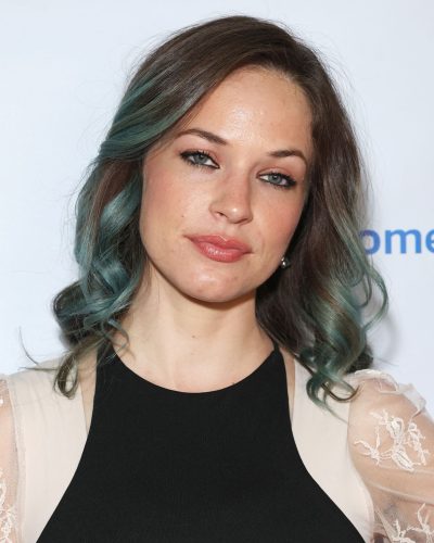 Alexis Knapp black jumpsuit complemented by vibrant teal hair.
