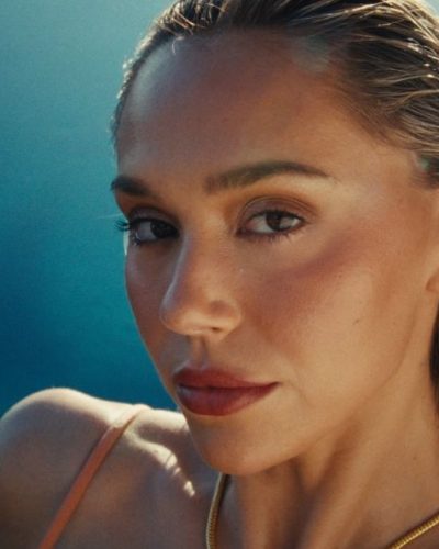 Alexis Ren wearing a peach bikini with layered gold accessories