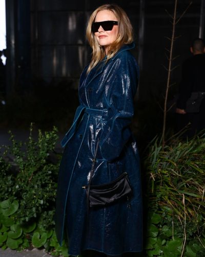 Alicia Silverstone wearing glossy trench coat with classic double-breasted design