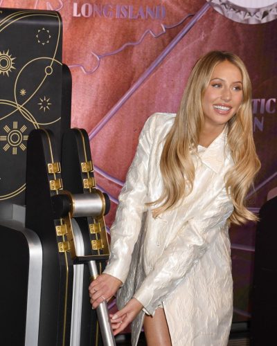 Alix Earle in a fitted white mini dress and cream pumps