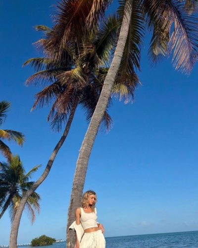 Allison Mason wearing halter neck black bikini by the ocean.