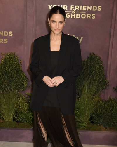 Amanda Peet with a fringed skirt and classic black heels.