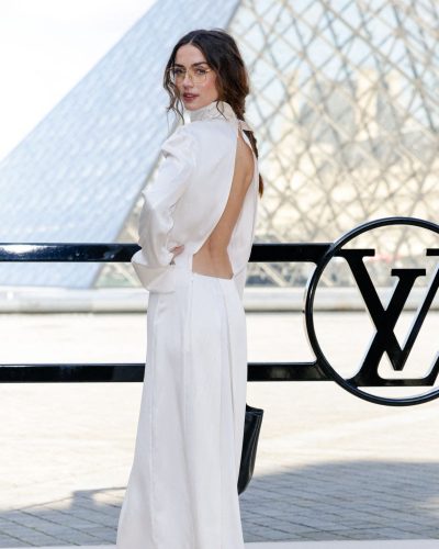 Ana de Armas in a refined black dress with golden frame glasses.