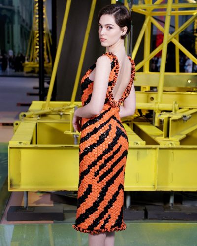 Anamaria Vartolomei in tailored orange gown with black accents