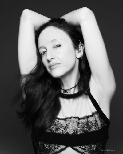 Andrea Riseborough wearing black graphic tee and white skirt ensemble