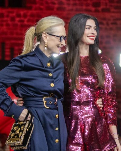 Anne Hathaway radiant smile with vibrant dress