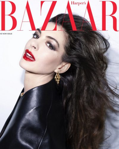 Anne Hathaway styled in black waistcoat and soft wavy hair.