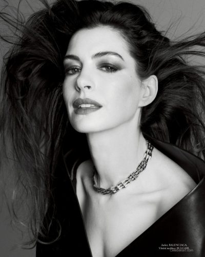 Anne Hathaway dressed in black waistcoat with intricate details.