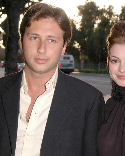 Anne Hathaway black high-neck ruffled top with tailored slacks