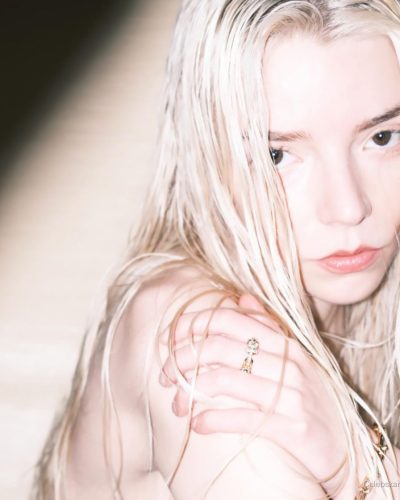 Anya Taylor-Joy in a sleek white outfit with gold ring