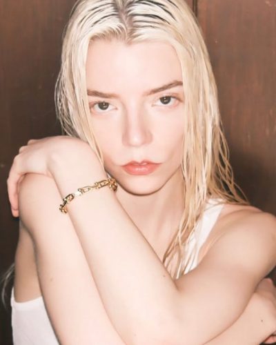 Anya Taylor-Joy wearing a white gown with eye-catching gold details