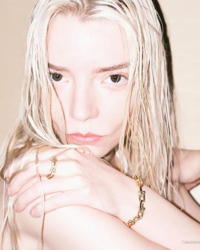 Anya Taylor-Joy wearing a white gown with gold bracelet