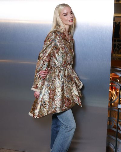 Anya Taylor-Joy gold coat and modern light denim jeans