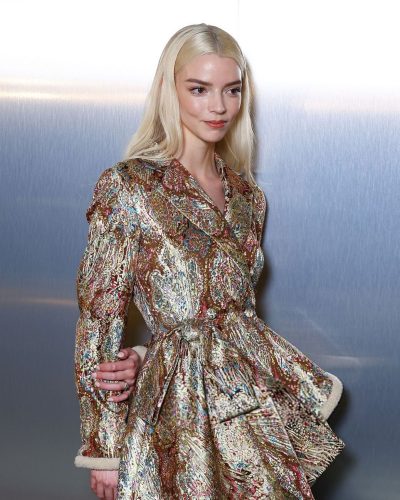 Anya Taylor-Joy shiny gold coat with chic denim trousers