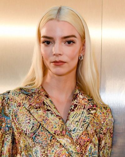 Anya Taylor-Joy shimmering gold outerwear and light denim jeans