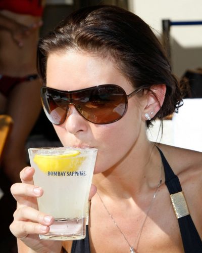 Audrina Patridge sporting a black swimsuit with modern cutouts.