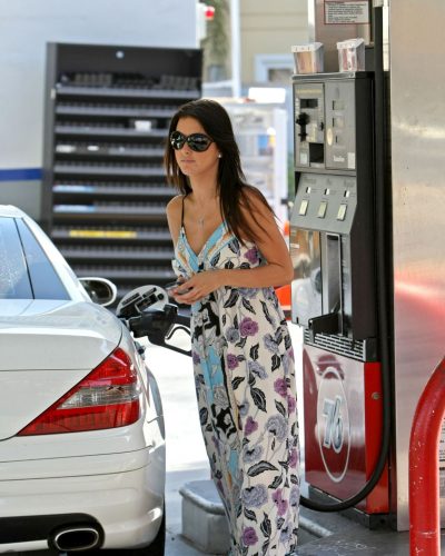 Audrina Patridge styled in a vibrant floral maxi dress and sunglasses.