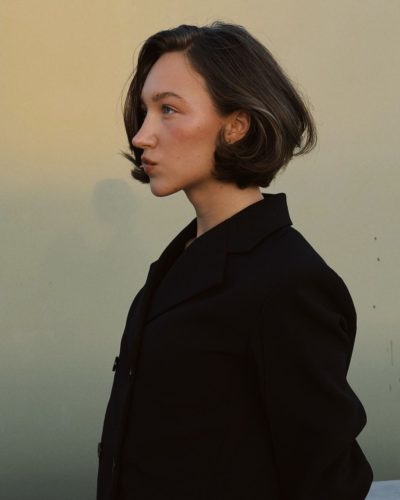 Ava Michelle in vibrant red jumpsuit with statement belt.