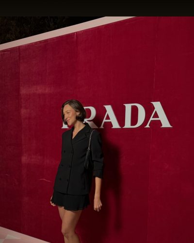 Ava Michelle in fitted white dress with delicate details.