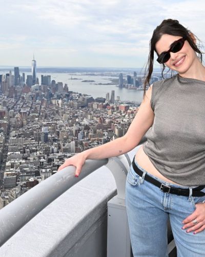 Barbie Ferreira casual denim and metallic top against city skyline.