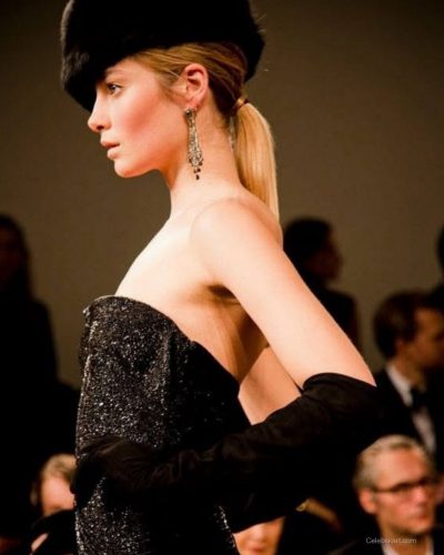 Bridget Malcolm in stylish black bikini seated on a boat.
