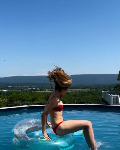 Bridget Malcolm in sleek black bikini enjoying summer vibes.