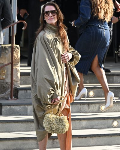 Brooke Shields in light tan gown paired with olive green cape.