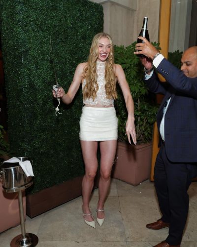 Cameron Brink styled in a beige lace shirt and sparkling skirt.