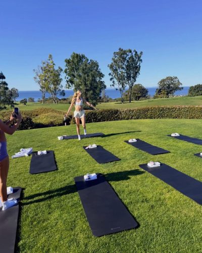 Cameron Brink featuring a beige lace shirt and shimmering mini skirt.