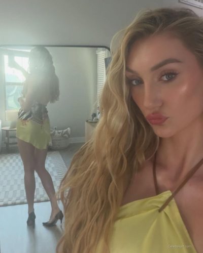 Cameron Brink wearing a bright yellow dress and purple handbag.