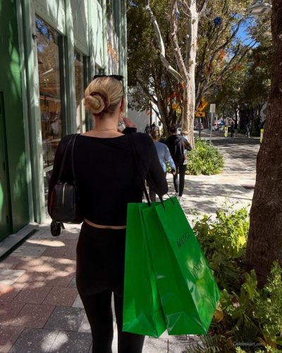 Cameron Brink styled in yellow gown with a small purple purse.