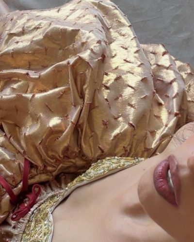 Camila Cabello in a red bikini against a palm tree.