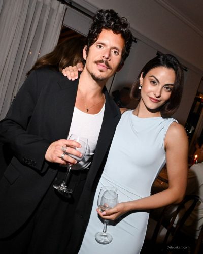 Camila Mendes in pale blue one-shoulder dress with embellished minaudière.