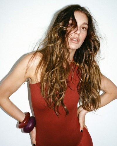 Camila Morrone in a red jumpsuit paired with bold bangles