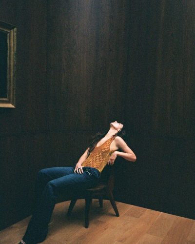 Camila Morrone in a vibrant red bodysuit and bold bangles